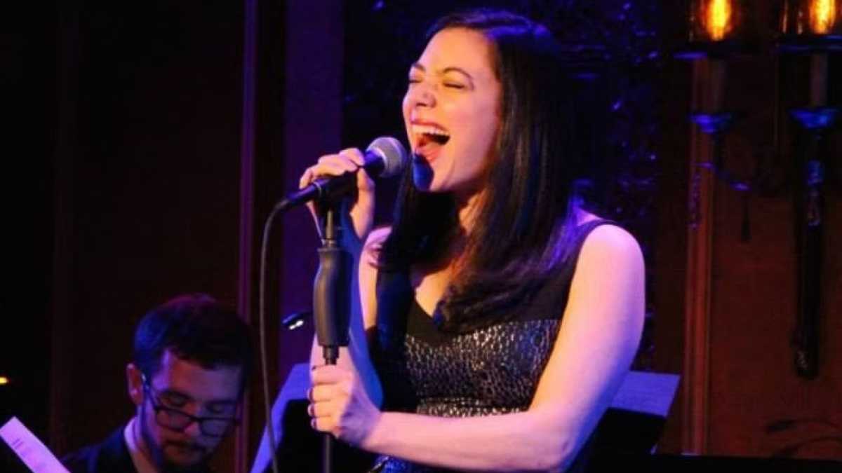 Julie Benko singing at a microphone