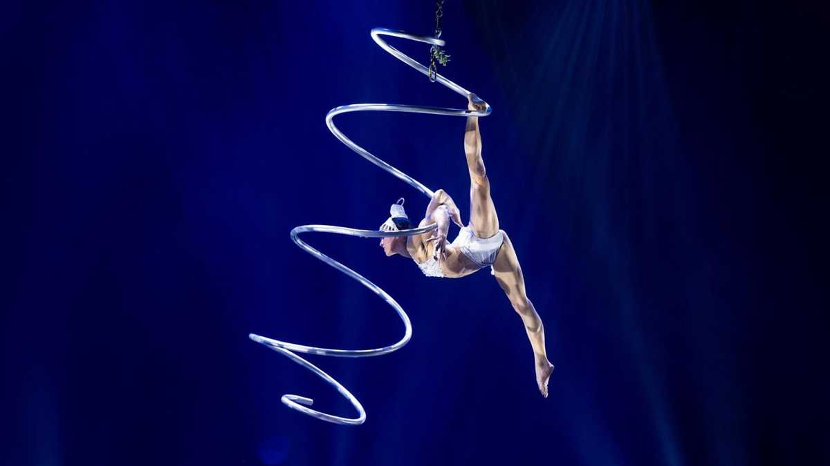 A Magical Cirque Christmas aerialist hangs on a cascading loop