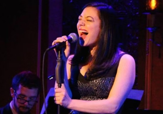 Julie Benko singing at a microphone